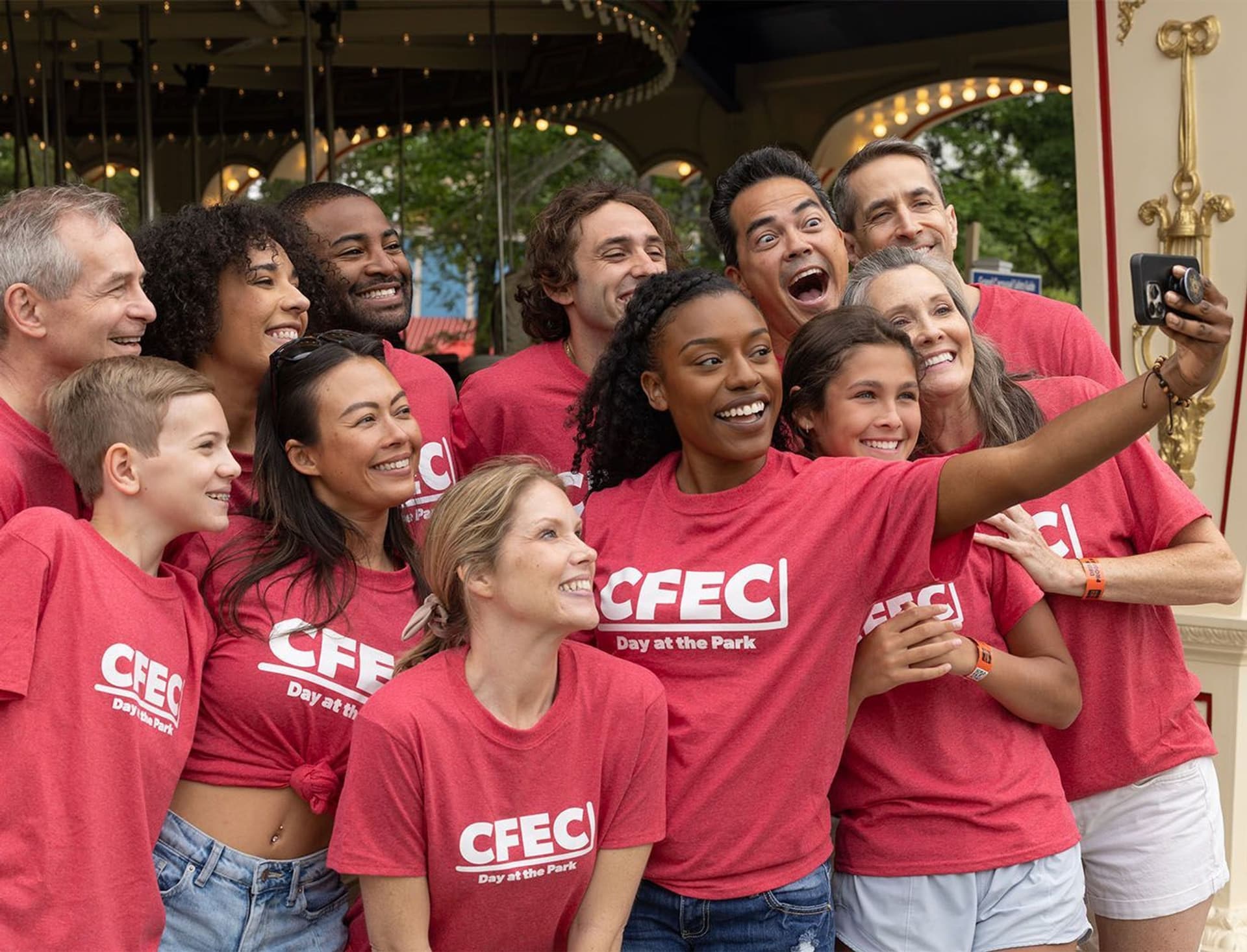 A group taking a selfie at an amusement park.