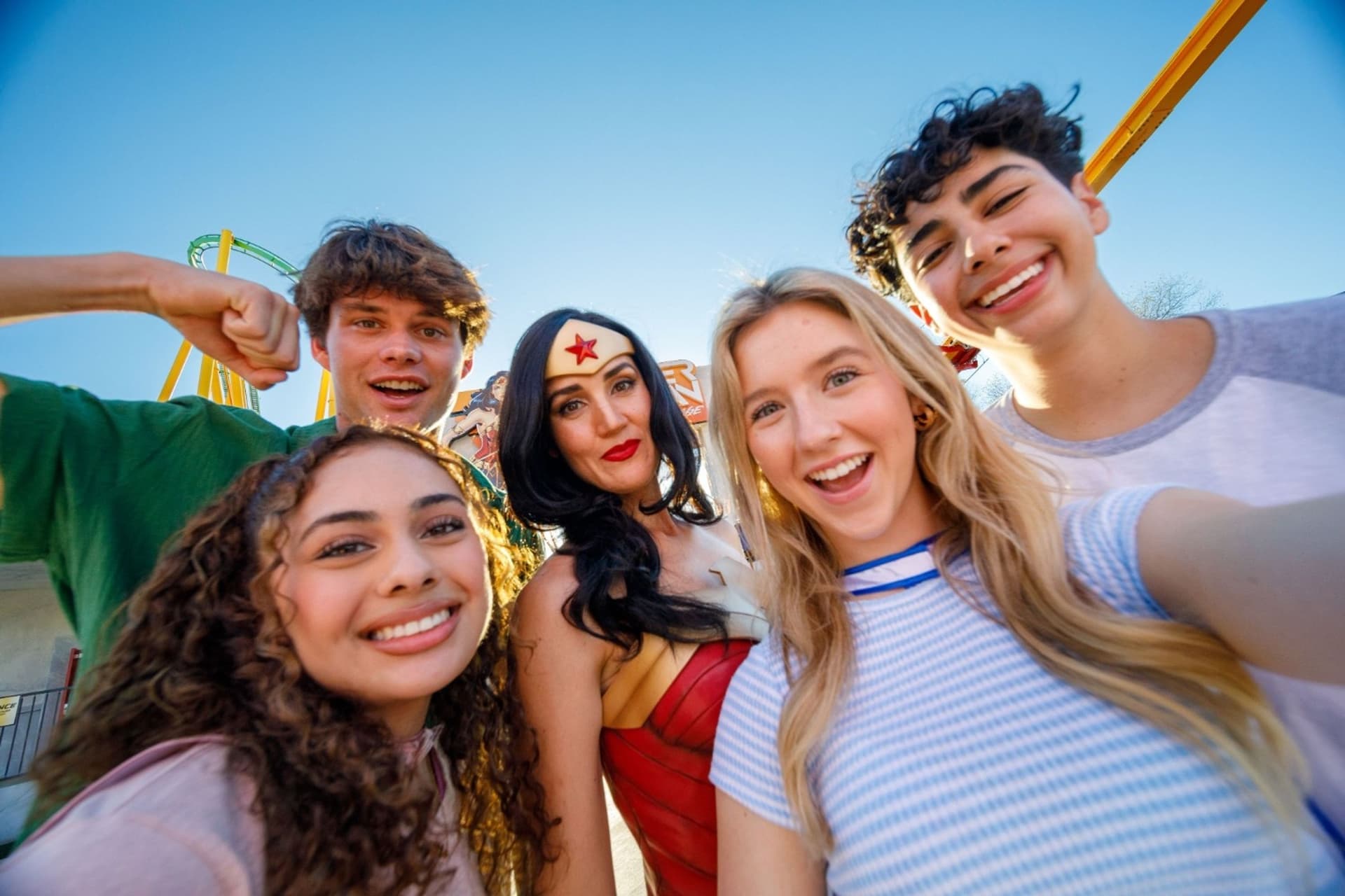 Four guests smiling and posing with WONDER WOMAN for a selfie. One of the many fun things to do in the bay area.