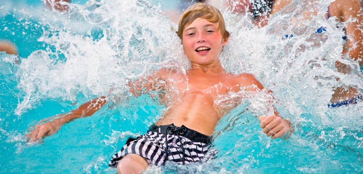 A boy splashing in a wave pool.